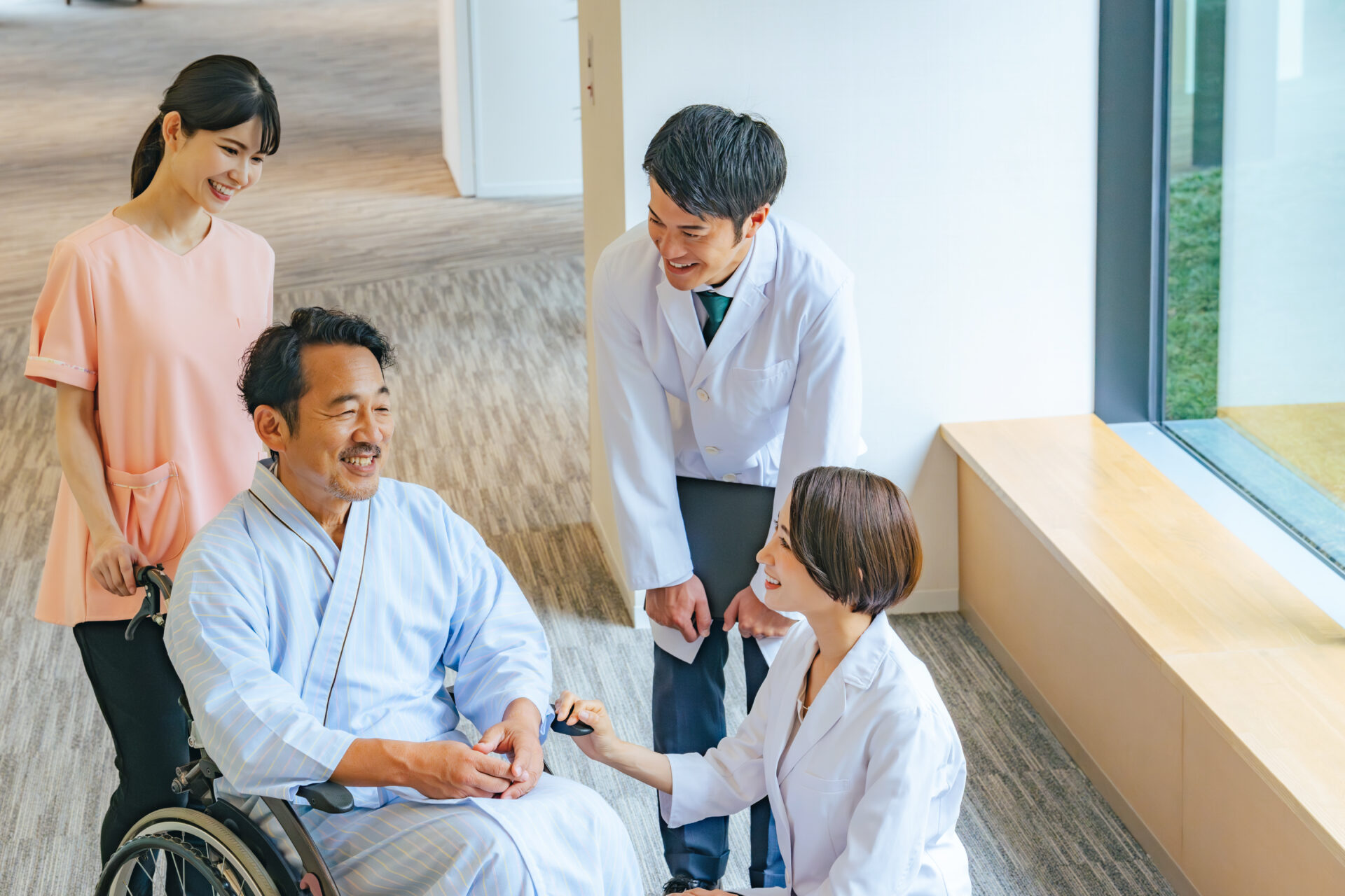【画像】車椅子のシニア男性患者と会話する医師